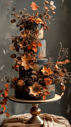 a three tiered cake decorated with flowers and leaves