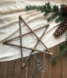 the star of david is made out of twigs and branches, next to pine cones