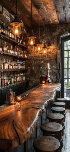 a long wooden bar with stools and bottles on it