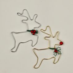 three metal reindeer ornaments with red berries on them