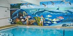 an indoor swimming pool with murals on the wall