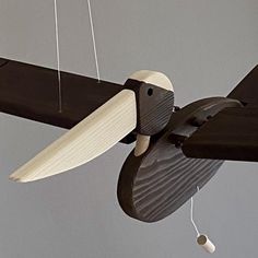 an airplane is flying in the sky with strings hanging from it's wing and propeller