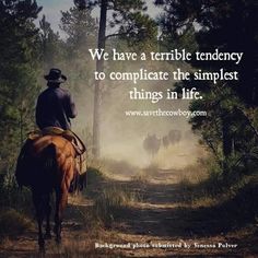 a man riding on the back of a brown horse down a dirt road next to trees