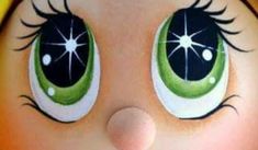 a close up view of the eyes and nose of a doll's face, with bright green eyeliners