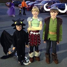 three children dressed up in costumes standing next to each other with horns on their heads