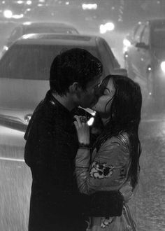 a man and woman kissing in the rain