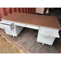 an old wooden desk with two drawers on the bottom, and one drawer is missing