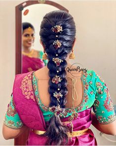 a woman with long hair in a pink sari is looking at herself in the mirror