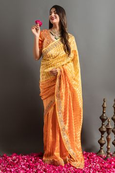 Yellow and orange saree with an ombre woven stripe base highlighted by zardozi embroidery. Comes with matching embroidered blouse.
Components: 2
Pattern: Embroidered
Type Of Work: Zardozi, Gotapatti
Neckline: Round
Sleeve Type: Half
Fabric: Tissue
Color: Orange,Yellow
Other Details: 
Woven zari stripes
Placed embroidery
Occasion: Mehendi and Haldi,Sangeet - Aza Fashions Orange Pre-draped Saree With Cutdana, Festive Orange Pre-draped Saree With Cutdana, Navratri Orange Tissue Silk Saree, Orange Tissue Silk Saree For Navratri, Orange Tissue Silk Saree With Dupatta, Orange Anarkali Chanderi Blouse Piece, Orange Anarkali Chanderi Saree, Orange Chanderi Pre-draped Saree For Navratri, Anarkali Chanderi Blouse Piece In Orange