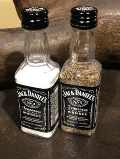 two bottles of jack daniels spices sitting on a table