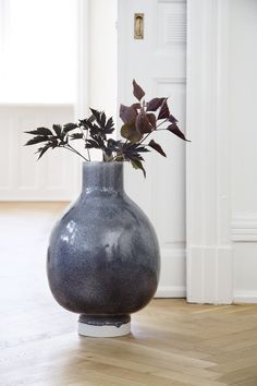 a vase with some flowers in it on the floor