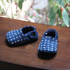 two baby shoes sitting on top of a wooden table