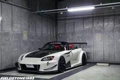 a white and black sports car parked in a garage