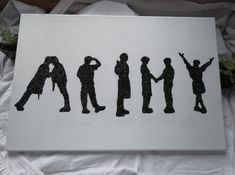 the silhouettes of people are painted on a white piece of paper with black ink