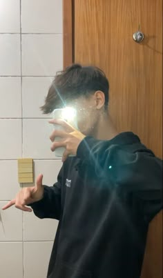 a man is taking a selfie in front of a mirror with his hand out