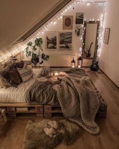 an attic bedroom decorated with string lights and blankets on the bed, along with other decorations