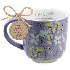 a purple mug with yellow flowers and a tag that says happy birthday on it, sitting next to a white background