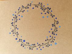 a piece of brown paper with blue sprigs on it and a circle drawn in the middle