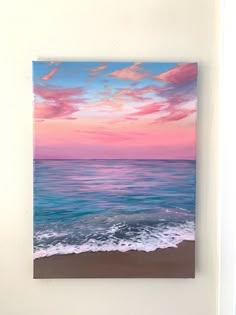 a painting on the wall of a beach with waves coming in to shore at sunset