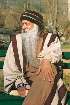 an old man with a long white beard sitting on a bench