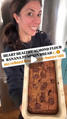 a woman holding up a large loaf of baked bread in front of her face and the words, heart healthy almond flour banana pumpkin butter roll