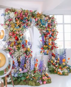 an instagram photo with flowers on the wall and in front of it is a letter made out of fake flowers