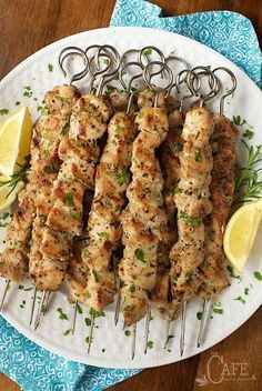 grilled chicken skewers with lemon wedges on a plate