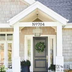 a gray front door with a wreath on it