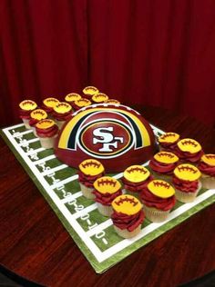 cupcakes are arranged in the shape of a football helmet on top of a table