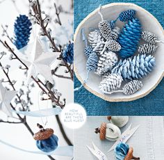 blue and white ornaments are hanging from the branches in front of a bowl filled with pine cones