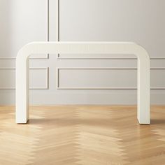 a white bench sitting on top of a hard wood floor