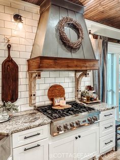 a kitchen with white cabinets and a wood burning stove top oven in front of a window