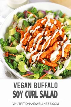 vegan buffalo soy curl salad in a white bowl with dressing drizzled on top