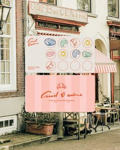 a sign that is on the sidewalk in front of a building with an awning