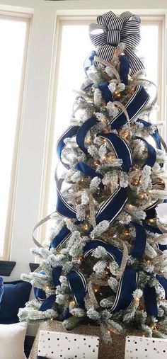 a blue and white christmas tree decorated with ribbon