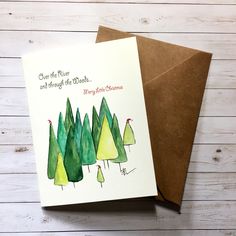 a christmas card with watercolor trees on it