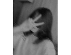 a blurry image of a woman brushing her hair