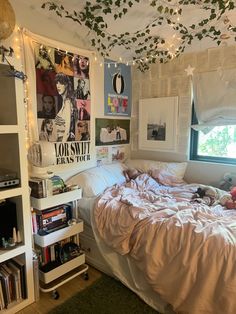 an unmade bed in a dorm room with bookshelves and pictures on the wall