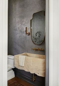 a bathroom with a sink, mirror and rug on the floor in front of it