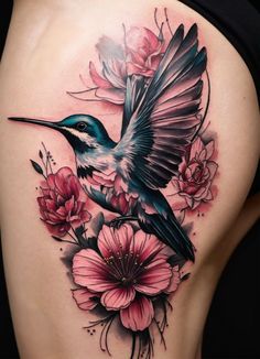 a woman's back with flowers and a hummingbird tattoo on her side ribcage