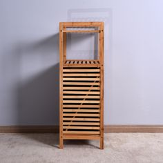 a wooden shelf sitting on top of a carpeted floor next to a white wall