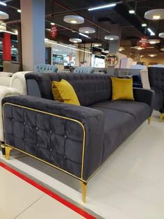 a couch with yellow and blue pillows in a showroom for furniture store or home decor