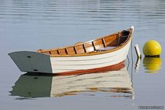 a small boat floating on top of a lake next to a yellow buoy