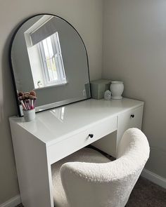 a white desk with a mirror and chair