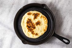 an omelette in a cast iron skillet on top of a white table