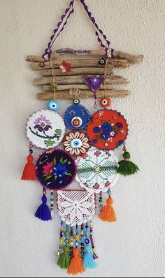 a wall hanging made out of wood sticks and various colorful decorations on it's side