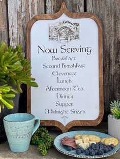 a sign that says notu serving next to some fruit on a plate and potted plant