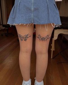 the back of a woman's legs with tattoos on them