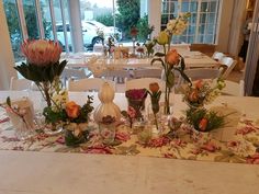 a table with flowers and vases on it