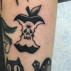 an apple and skull tattoo on the leg